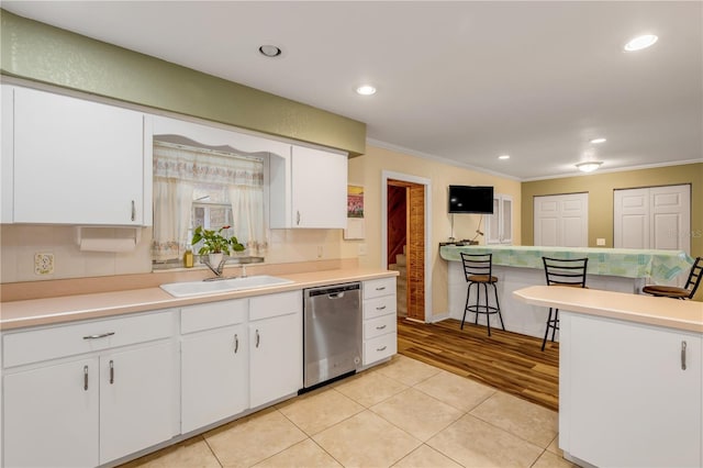 kitchen with white cabinets, ornamental molding, sink, dishwasher, and light hardwood / wood-style floors