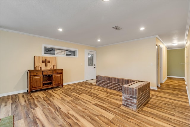 interior space with light hardwood / wood-style floors and ornamental molding