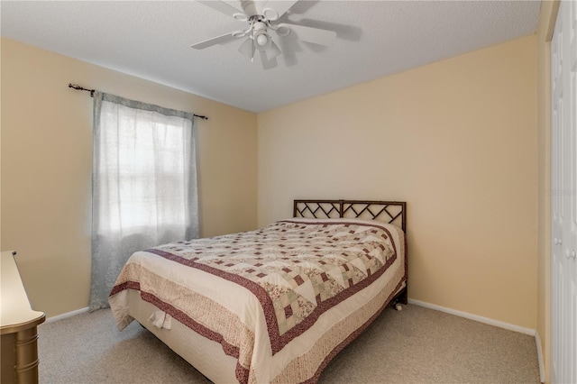 bedroom with ceiling fan, a closet, light carpet, and a textured ceiling