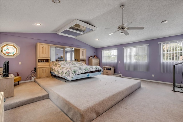 bedroom featuring ceiling fan, light colored carpet, lofted ceiling, and a textured ceiling