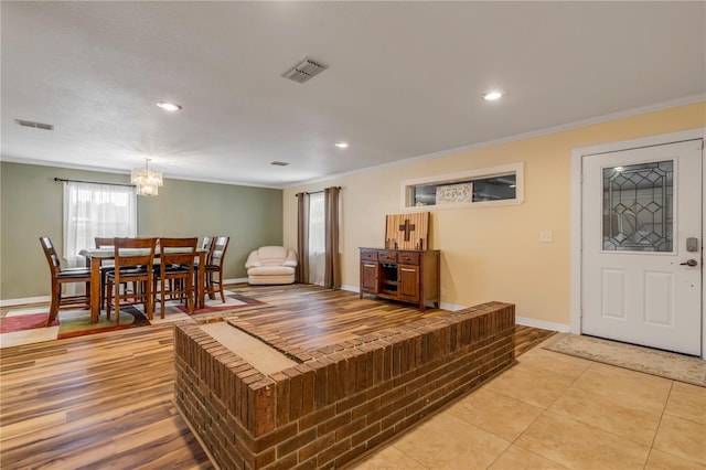 tiled living room with an inviting chandelier and ornamental molding