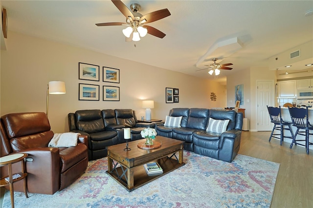 living room featuring ceiling fan and light hardwood / wood-style floors