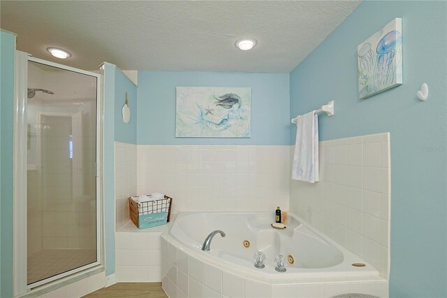 bathroom featuring plus walk in shower, a textured ceiling, and hardwood / wood-style flooring