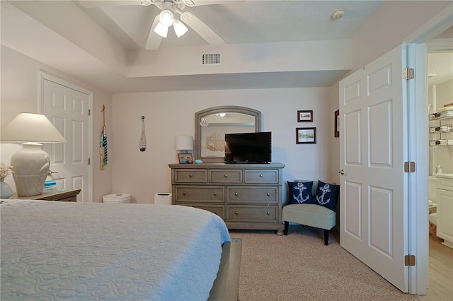 bedroom featuring connected bathroom, ceiling fan, and light colored carpet