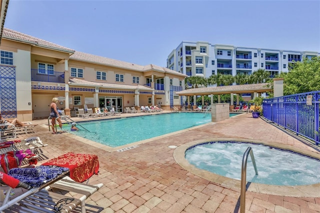 view of pool with a patio and a hot tub