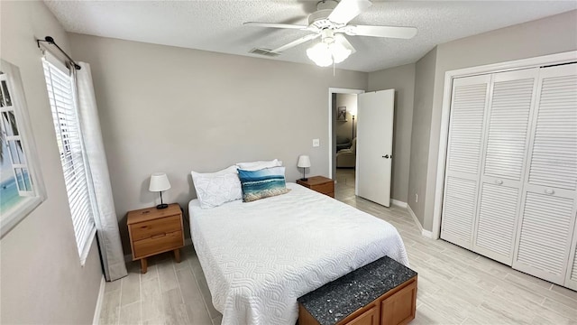 bedroom featuring a textured ceiling, ceiling fan, light hardwood / wood-style flooring, and a closet