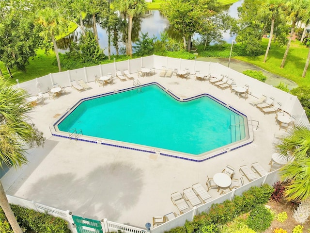 view of swimming pool featuring a water view and a patio