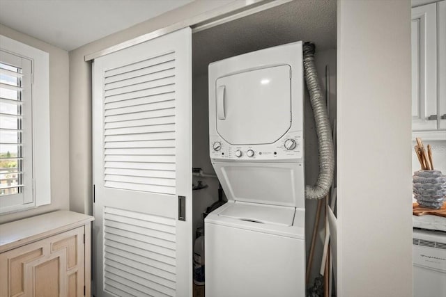 washroom featuring stacked washer / drying machine