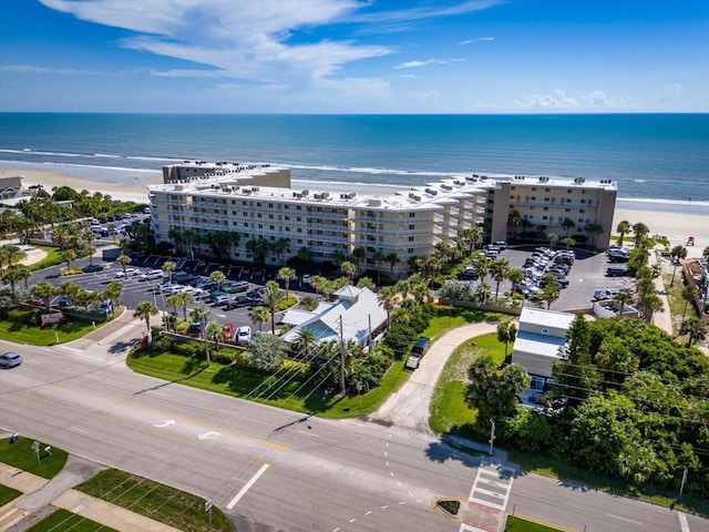 birds eye view of property with a water view and a beach view