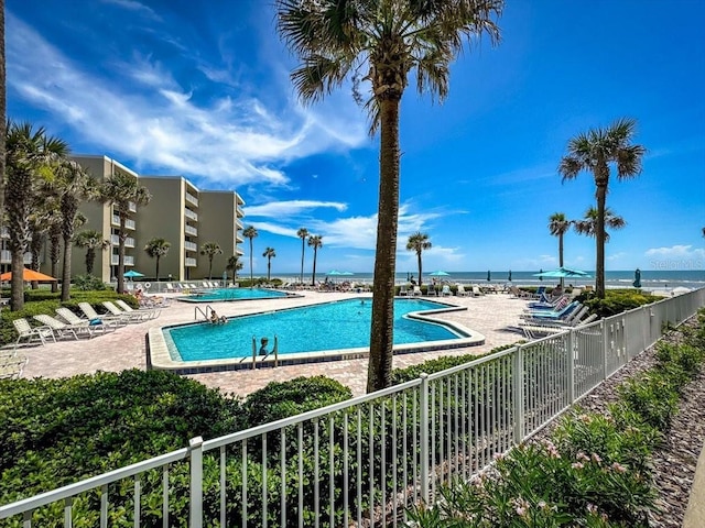 view of pool with a patio and a water view