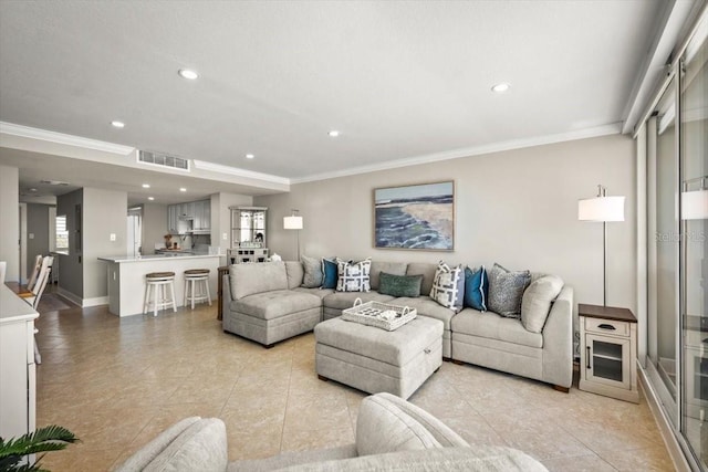 living room featuring ornamental molding and light tile patterned flooring