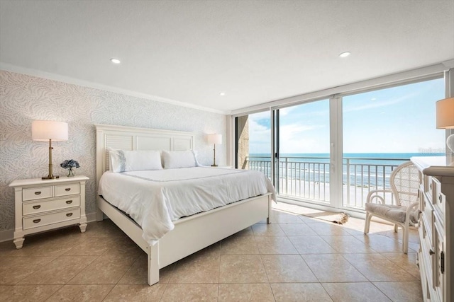 tiled bedroom featuring expansive windows, a water view, access to exterior, ornamental molding, and a beach view