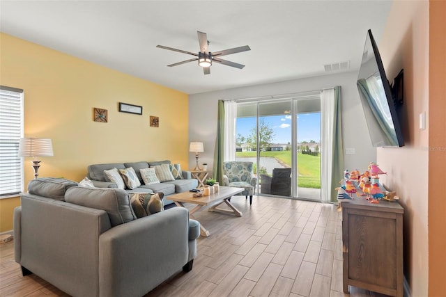 living room featuring ceiling fan and a healthy amount of sunlight