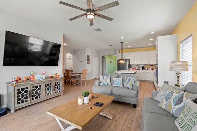 living room with light hardwood / wood-style flooring and ceiling fan