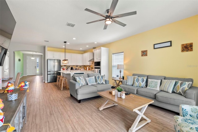 living room featuring light wood-type flooring and ceiling fan