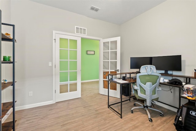 home office with french doors and light hardwood / wood-style floors