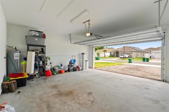 garage with electric water heater and a garage door opener