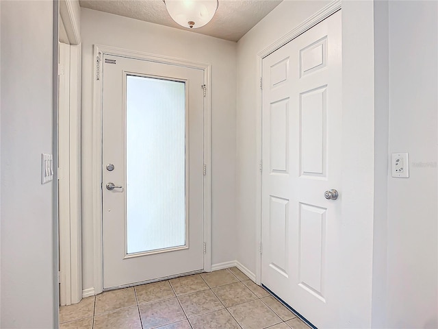 entryway featuring a textured ceiling and light tile patterned floors