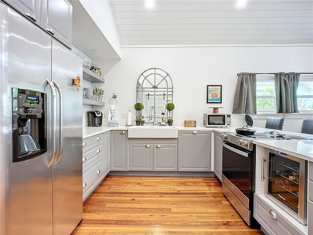 kitchen with sink, wine cooler, gray cabinets, appliances with stainless steel finishes, and light hardwood / wood-style floors