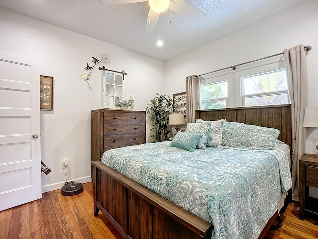 bedroom with ceiling fan and hardwood / wood-style flooring