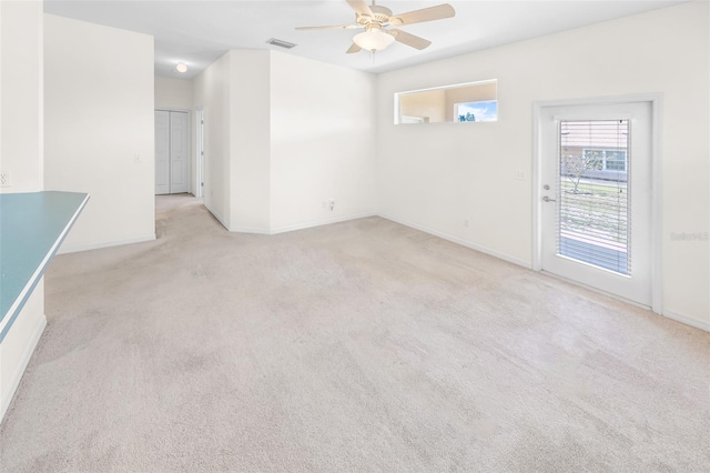 empty room with ceiling fan, visible vents, baseboards, and light colored carpet