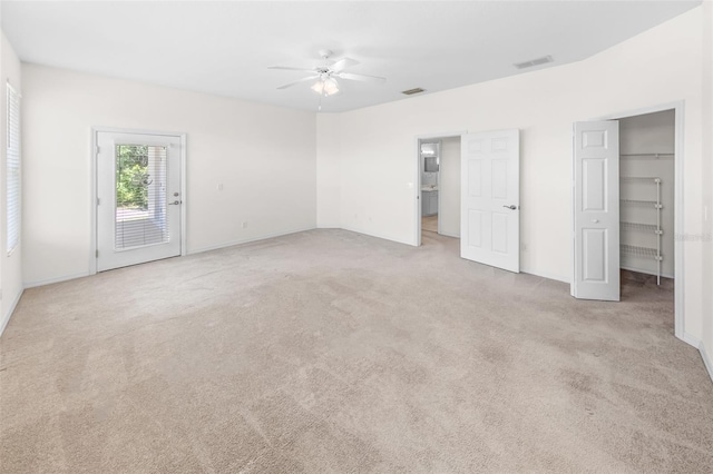 unfurnished bedroom featuring access to exterior, a ceiling fan, visible vents, and light colored carpet