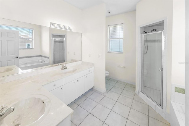 bathroom featuring toilet, tile patterned flooring, a shower stall, and a sink