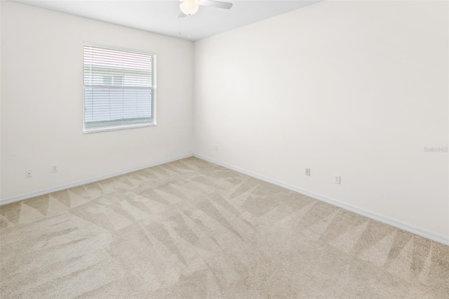 empty room with light carpet, ceiling fan, and baseboards