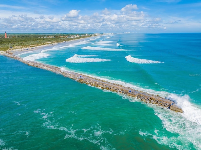 drone / aerial view featuring a beach view and a water view