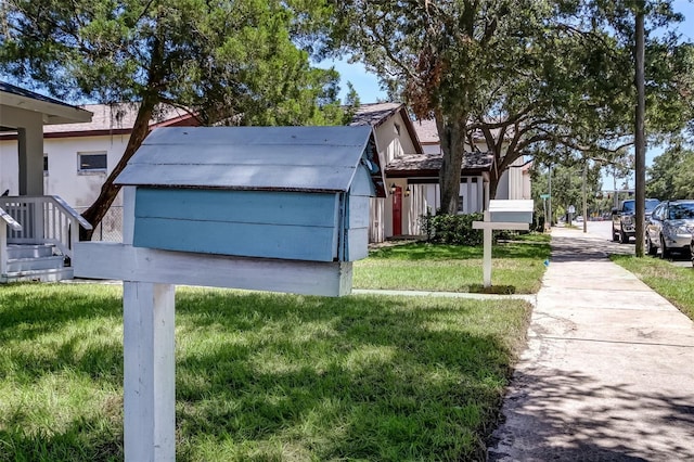 view of front of property featuring a front lawn and a storage shed