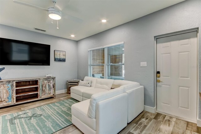 living room featuring ceiling fan and light hardwood / wood-style floors