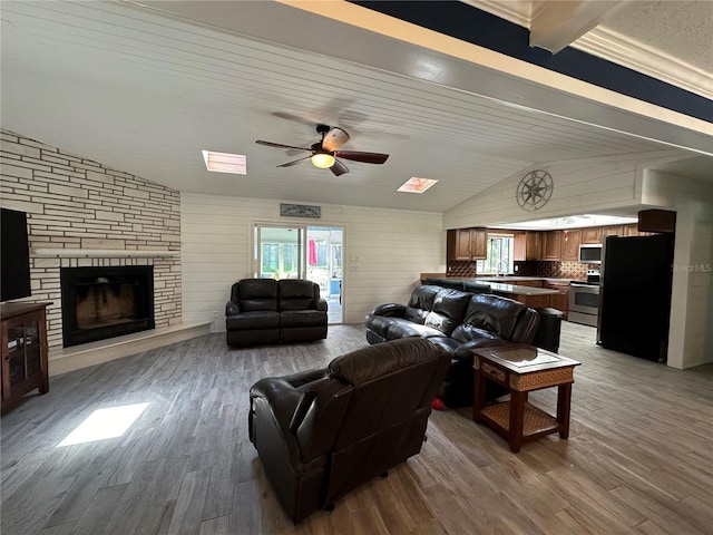 living room with wood ceiling, vaulted ceiling, ceiling fan, a fireplace, and hardwood / wood-style floors