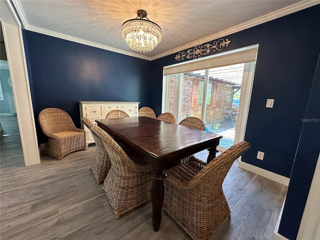 dining space featuring a notable chandelier, crown molding, and a textured ceiling