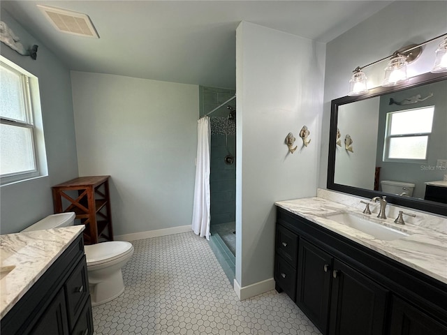 bathroom with a shower with shower curtain, tile patterned floors, vanity, and toilet