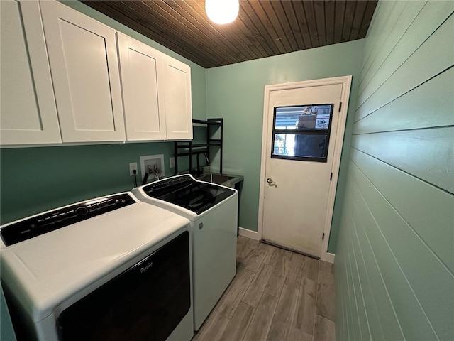 washroom with cabinets, washing machine and dryer, light hardwood / wood-style flooring, and wooden ceiling