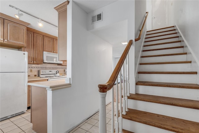 stairway with tile patterned flooring and rail lighting