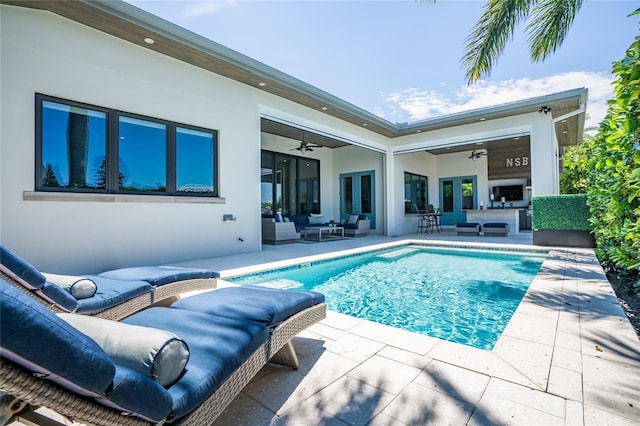 view of swimming pool featuring french doors, ceiling fan, an outdoor hangout area, and a patio