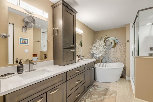 bathroom with hardwood / wood-style floors, vanity, and separate shower and tub