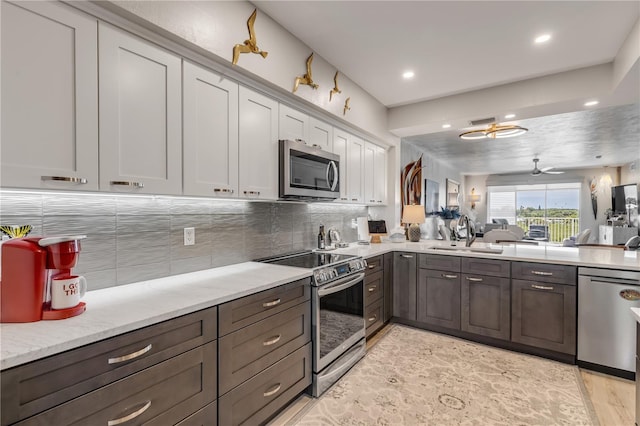 kitchen with ceiling fan, sink, stainless steel appliances, and tasteful backsplash