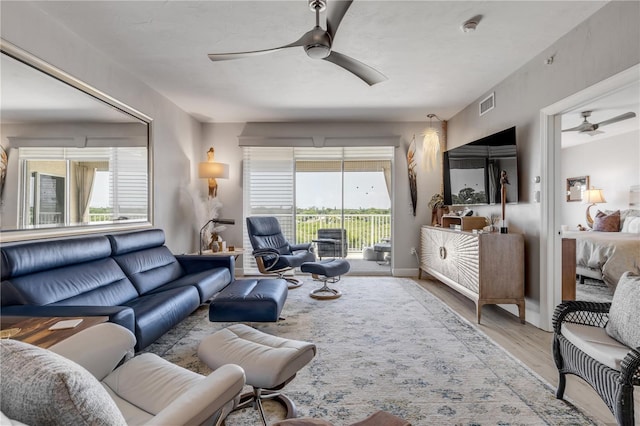 living room featuring ceiling fan and light hardwood / wood-style flooring