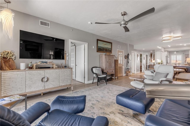 living room featuring ceiling fan and light wood-type flooring