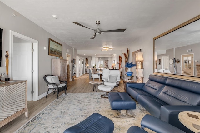 living room with light wood-type flooring and ceiling fan