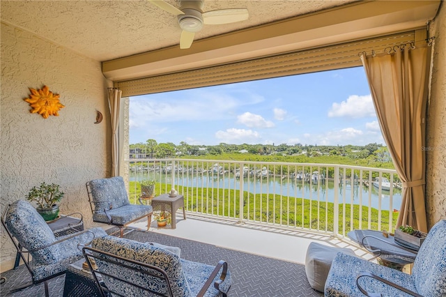 sunroom with ceiling fan, a water view, and a wealth of natural light