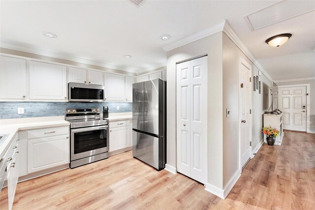 kitchen with white cabinetry, appliances with stainless steel finishes, tasteful backsplash, crown molding, and light hardwood / wood-style flooring