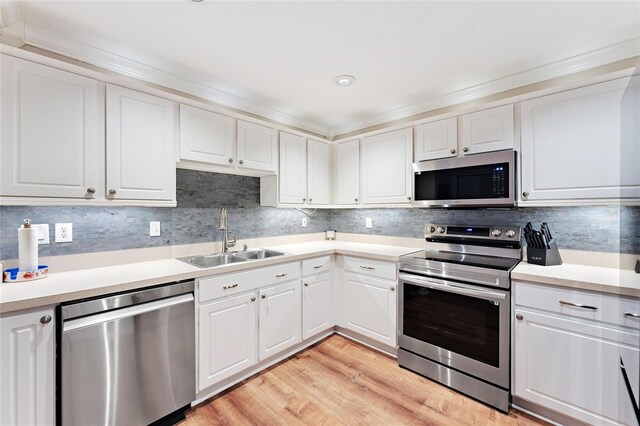 kitchen featuring sink, white cabinets, light hardwood / wood-style flooring, and stainless steel appliances