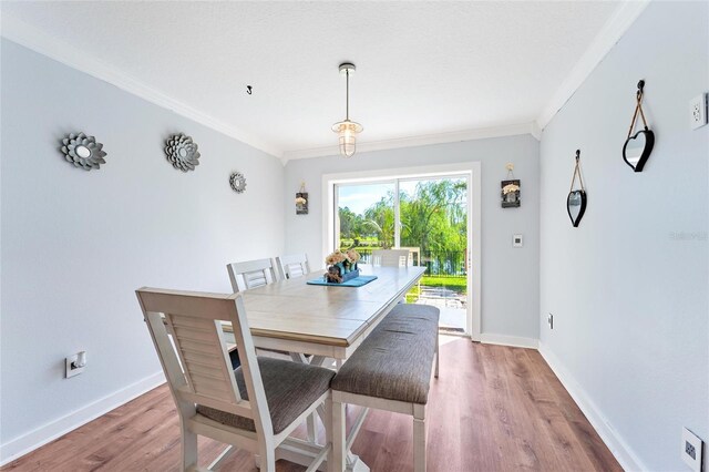 dining area featuring ornamental molding and hardwood / wood-style floors