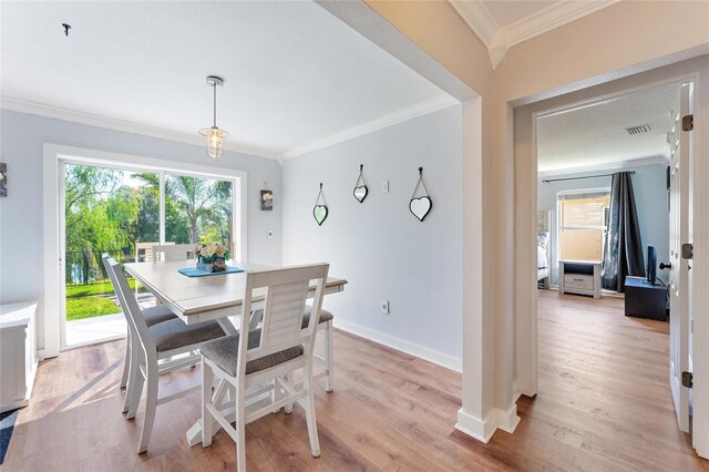 dining room with light hardwood / wood-style floors and ornamental molding