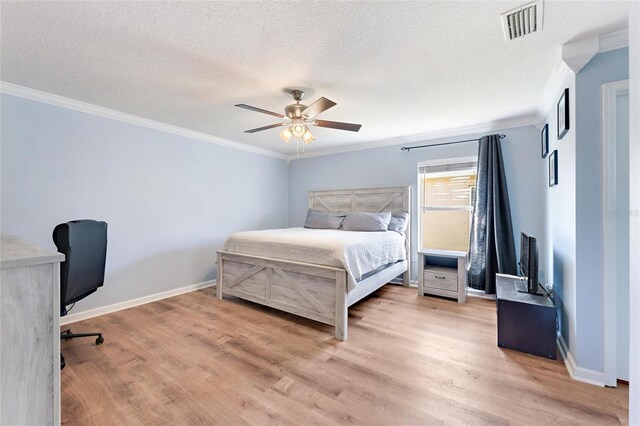 bedroom with ceiling fan, crown molding, a textured ceiling, and light hardwood / wood-style flooring