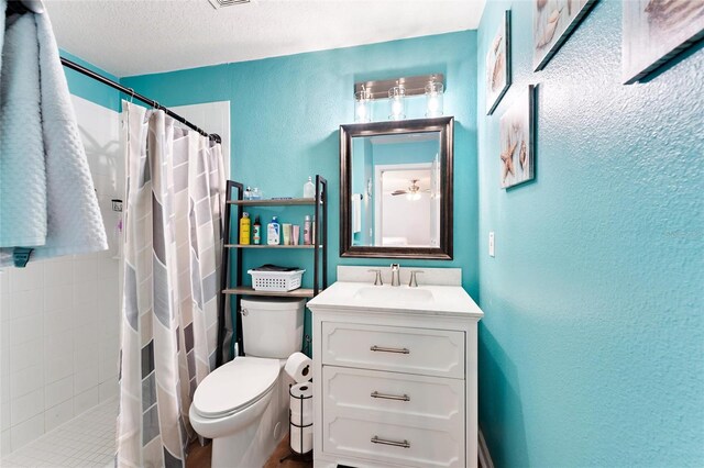 bathroom featuring a textured ceiling, toilet, vanity, and a shower with curtain