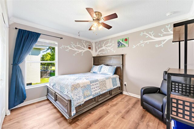 bedroom with ceiling fan, ornamental molding, and light hardwood / wood-style floors